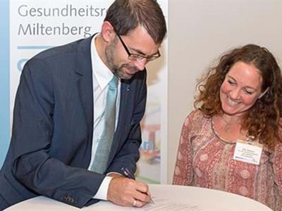 Landrat Jens Marco Scherf und Iris Grimm unterzeichneten eine Partnerschaftsvereinbarung, die die Kooperation zwischen Gesundheitsregion plus und Kooperationsverbund Gesundheitliche Chancengleichheit besiegelt.